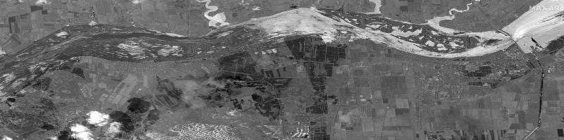 Imagen de satélite a gran escala que muestra cómo la enorme masa de agua desciende desde la presa por el curso del río arrasando los cultivos de las orillas.