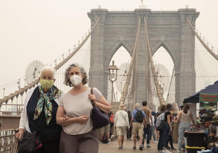 Varias personas usan mascarilla en las calles de Nueva York para evitar respirar el humo que cubre la ciudad tras la oleada de incendios producidos en Canadá