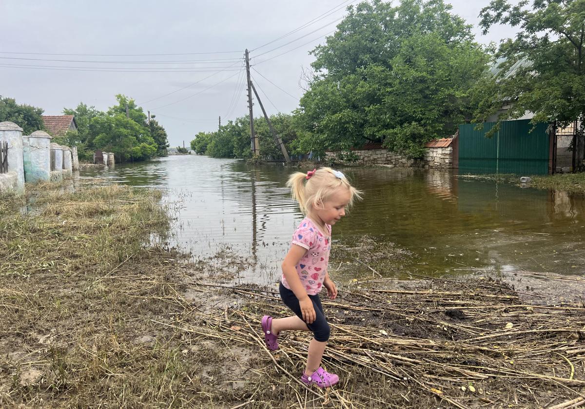 La pequeña Masha, de 3 años, corretea por una calle de Barativka convertida en un lodazal por las inundaciones.