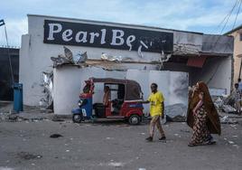Dos personas pasan junto al Hotel Pearl Beach en Mogadiscio donde ha ocurrido el ataque