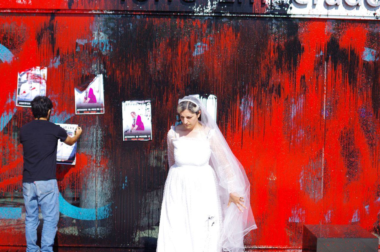 La activista Elena González vestida de novia y el cartel de su prometido Mike Lynch