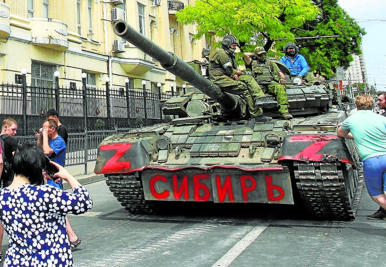 Varios civiles rusos, junto a un tanque de Grupo Wagner en Rostov.