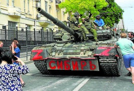 Varios civiles rusos, junto a un tanque de Grupo Wagner en Rostov.