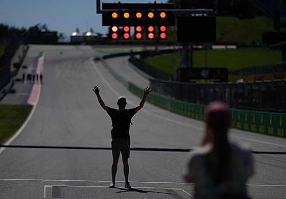 Un aficionado, fotografiado ante el semáforo del Red Bull Ring.