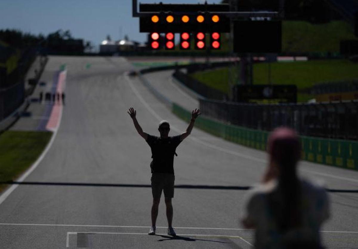 Un aficionado, fotografiado ante el semáforo del Red Bull Ring.