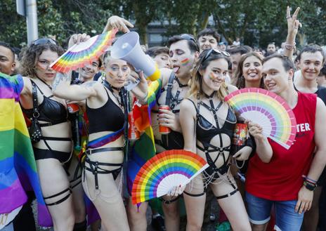 Imagen secundaria 1 - En la imagen superior, la cabecera política de la marcha del Orgullo en Madrid celebrada este sábado; debajo, varias de las personas que participaron en una jornada con marcado signo reivindicativo y, por último, una persona exhibe un curioso cartel con un lema elocuente.