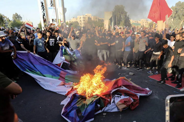 Manifestantes iraquíes queman una bandera LGTBI en las inmediaciones de la embajada sueca.