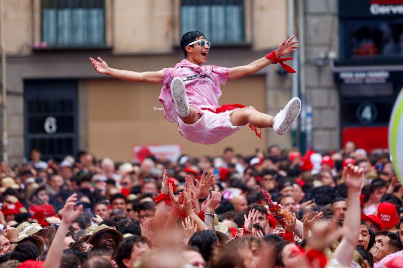 Un grupo de jóvenes mantea a un chico en la Plaza del Ayuntamiento de Pamplona.