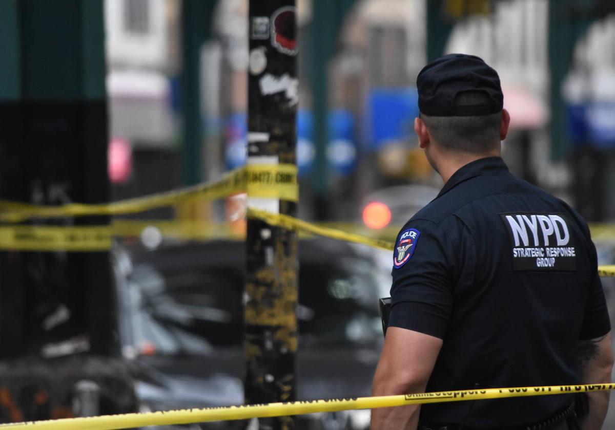 Un agente de la Policía de Nueva York vigila la zona acordonada donde tuvo lugar un tiroteo en el barrio de Brooklyn