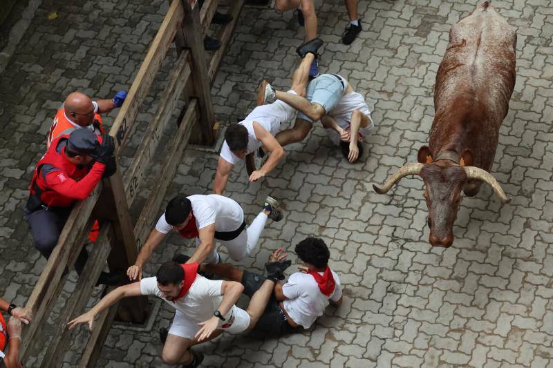 Varios mozos se tropiezan al paso de uno de los toros de la ganadería de Núñez del Cuvillo.