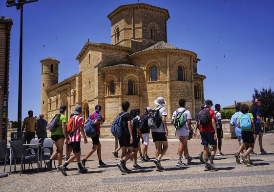 Un grupo de jóvenes pasa frente a la iglesia de San Martín, obra maestra de la arquitectura románica.