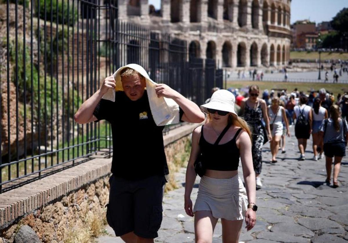 Turistas se protegen del intenso calor cerca del Coliseo, en el centro de Roma.