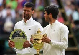 Alcaraz sonríe ante Djokovic mientras posa con el trofeo de campeón