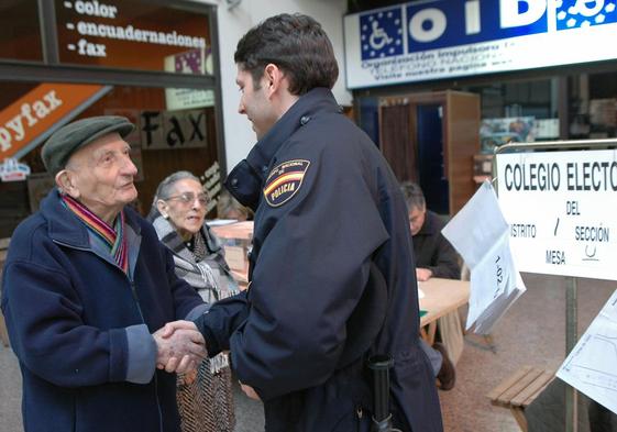 Un votante saluda a un policía tras haber emitido su voto en el colegio electoral