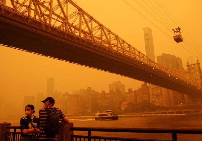 Dos personas en Roosevelt Island (Nueva York) cubiertos por el humo procedente de los incendios de Canadá