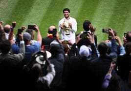 Carlos Alcaraz sostiene el trofeo de Wimbledon ante el público londinense.