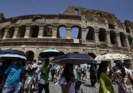 Paseantes se protegen del intenso calor en el centro de Roma, donde el mercurio ha llegado este miércoles a los 43 grados.