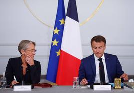 La primera ministra francesa, Élisabeth Borne, escucha al presidente francés, Emmanuel Macron, en una rueda de prensa.