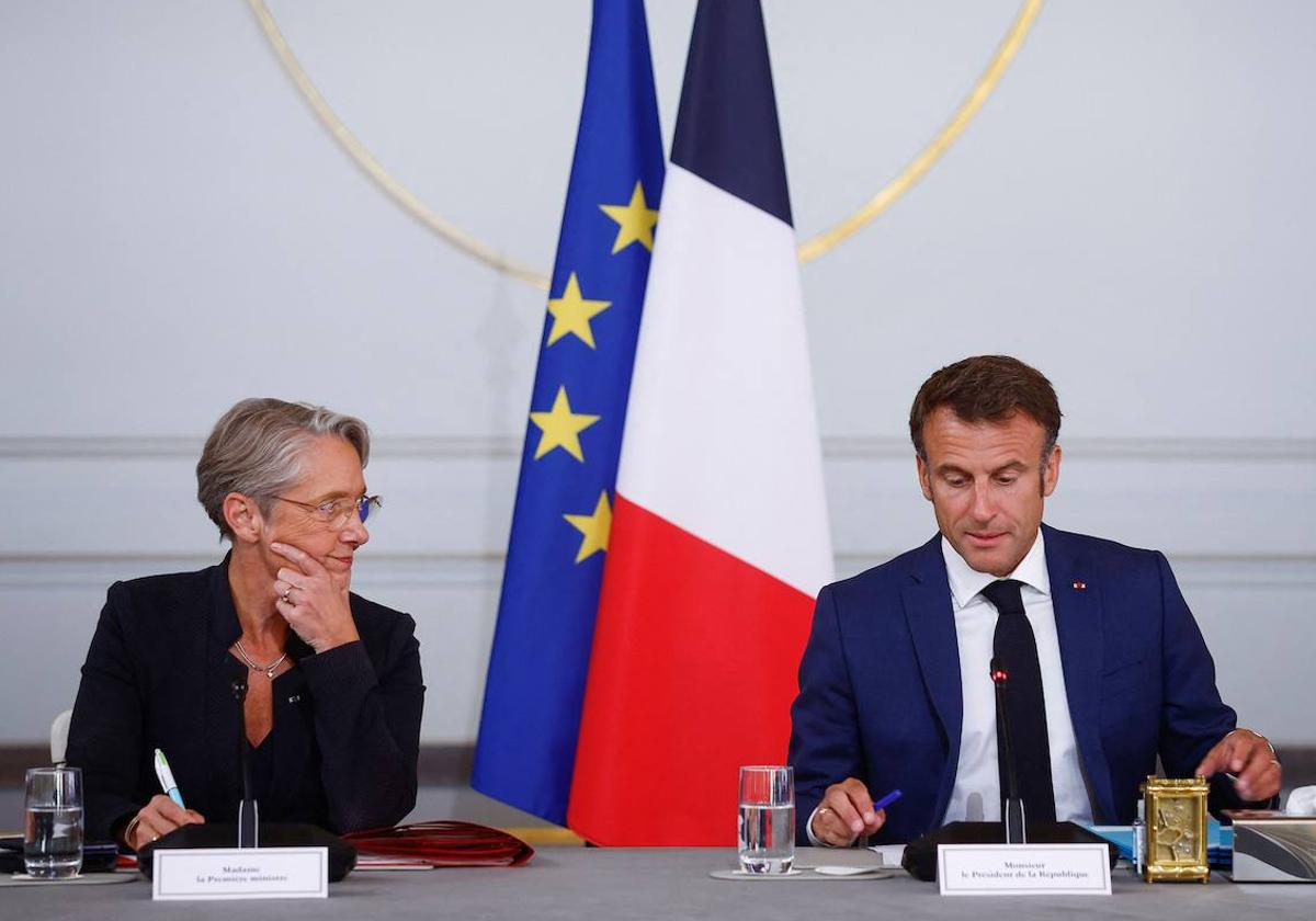 La primera ministra francesa, Élisabeth Borne, escucha al presidente francés, Emmanuel Macron, en una rueda de prensa.