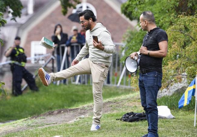 Salwan Momika patea una copia del Corán durante su manifestación frente a la embajada iraquí en Estocolmo.