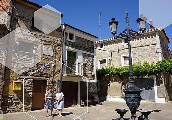 Dos vecinas conversan en la plaza de la iglesia de Valdeprado, donde un 85% del censo se encuentra fuera de España.