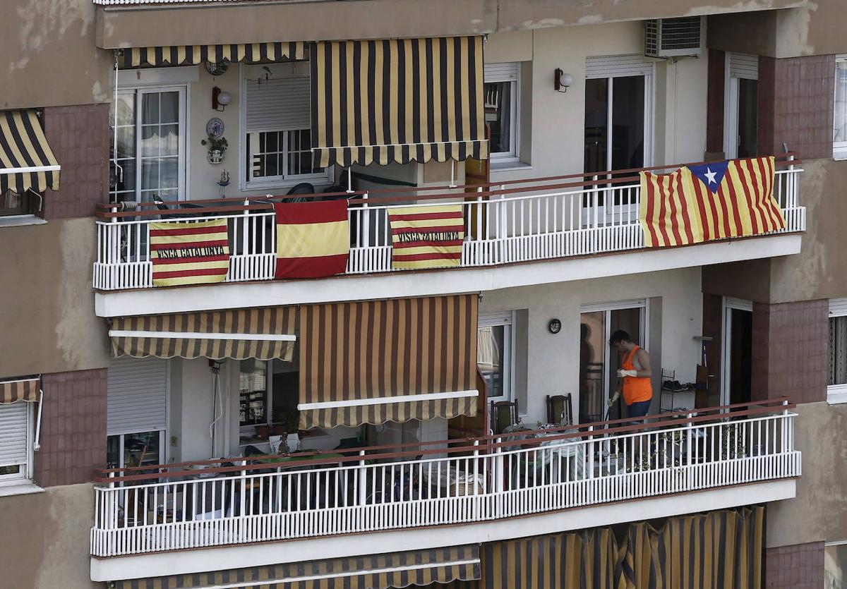 Banderas de Cataluña junto a una española y una estelada, adornan el balcón de un edificio en el centro de Barcelona.