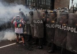 Policías antidisturbios bloquean el paso a una manifestante durante una protesta en Lima.