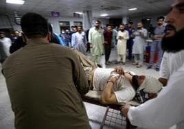 Un hombre es trasladado a un hospital de Peshawar tras resultar herido en el atentado perpetrado este domingo en la localidad de Jar.