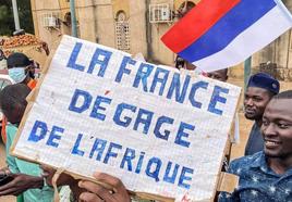 Manifestantes a favor de los golpistas en Niamey, Níger, con una bandera de Rusia y un carten en el que se lee: «Francia fuera de África».