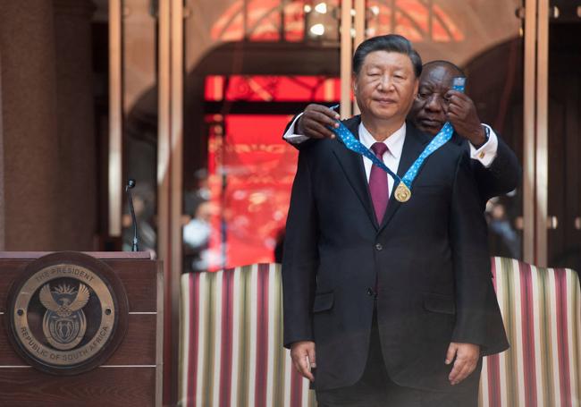 El presidente de Sudáfrica, Cyril Ramaphosa, impone una medalla a su homólogo chino, Xi Jinping