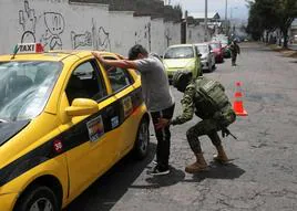 Un soldado cachea a un taxista en un puesto de control militar en Quito.