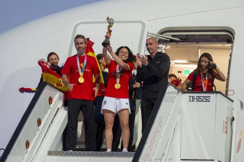 Ivana Andrés, junto a Jorge Vilda y Luis Rubiales, muestra el trofeo tras el aterrizaje del avión de la selección en Barajas.