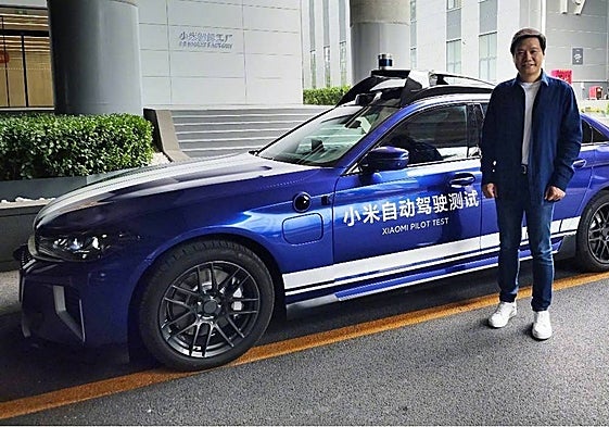 El consejero delegado de Xiaomi, Lei Jun, posa delante del piloto de automóvil