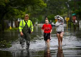 Residentes caminan por las calles inundadas en New Port Richey, Florida, tras el paso de 'Idalia'.
