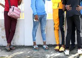 Hombres acusados ​​de mostrar afecto en público a miembros del mismo sexo esperan frente a un tribunal en Lagos.
