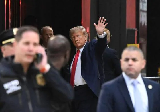 Donald Trump saluda al llegar a la Torre Trump en Nueva York