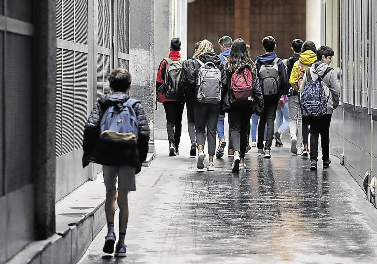 Varios alumnos caminan hacia su aula.