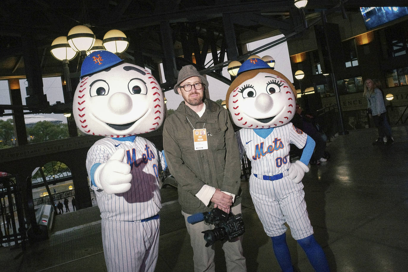 Wilson con dos mascotas de los New York Mets, a punto de encontrar al aficionado más estrambótico