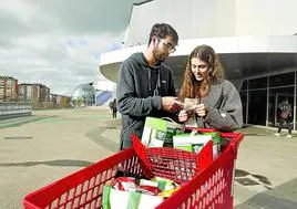 Una pareja revisa el tique de su compra a la salida del supermercado.