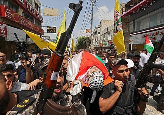 Las milicias palestinas portan el cadáver de una de las víctimas durante el funeral celebrado en Yenin.