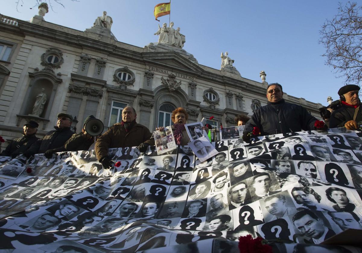 Manifestantes con imágenes de víctimas de franquismo durante, ante la sede del Tribunal Supremo.