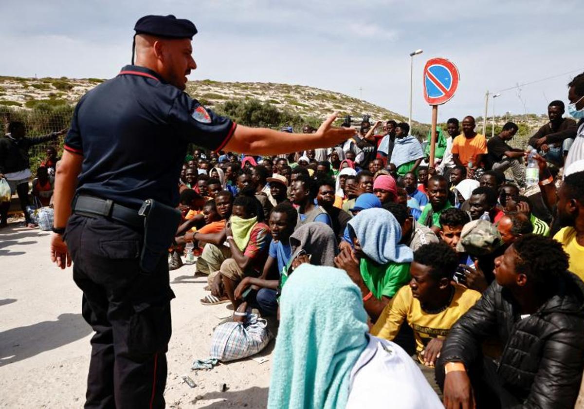 Un carabinieri intenta ordenar un grupo de migrantes tras desembarcar en la isla siciliana de Lampedusa.