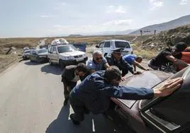 Un grupo de armenios empujan un coche averiado que obstaculiza la salida de Nagorno Karabaj.