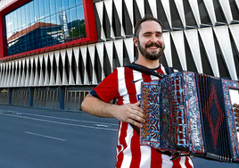 Jon Azanza posa ante San Mamés con la trikitixa y la camiseta que llevó en el derbi.