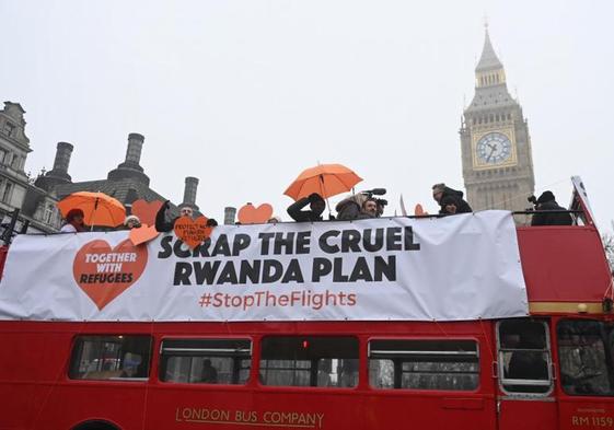 Activistas y partidarios de la organización benéfica para refugiados viajan en un autobús contratado para una protesta en la Plaza del Parlamento en Londres.