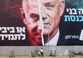 Un niño mira una pancarta de la campaña electoral del ministro de Defensa israelí, Benny Gantz, junto al primer ministro, Benjamin Netanyahu