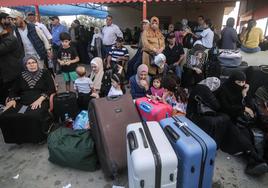 Decenas de palestinos esperaban en los alrededores del paso de Rafah en su huida de Gaza.