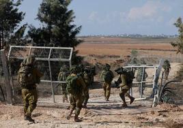 Soldados israelíes cruzaban este domingo la valla del kibutz Kfar Aza, delante de la Franja, cuyos habitantes fueron masacrados por Hamás hace diez días.