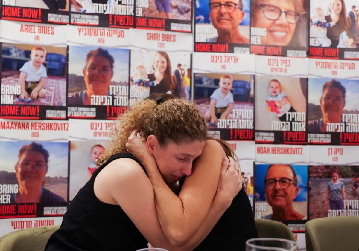 Dos mujeres cuyos familiares fueron secuestrados se consuelan mutuamente durante una rueda de prensa en Tel Aviv.