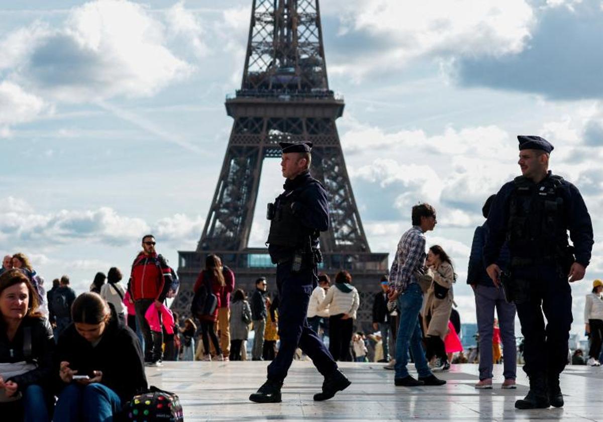 Varios gendarmes patrullan entre los turistas que visitan la plaza de Trocadero, junto a la Torre Eiffel de París.